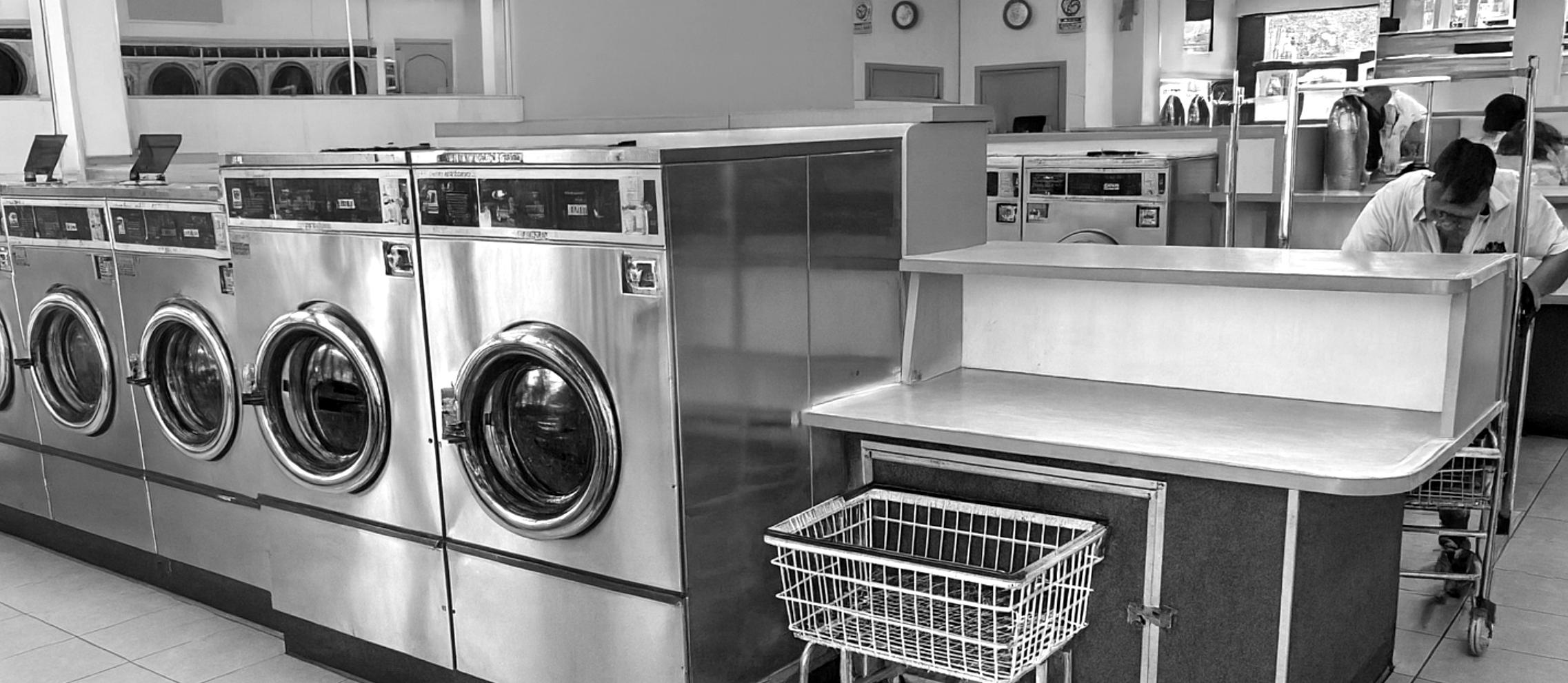 Rows of coin-op washers and the folding counter at Ball Lemon Coin Laundry